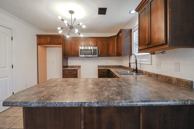 1206 Ryan Ln, Paragould, AR 72450 - kitchen featuring stainless steel microwave, ornamental molding, a peninsula, a chandelier, and dark countertops