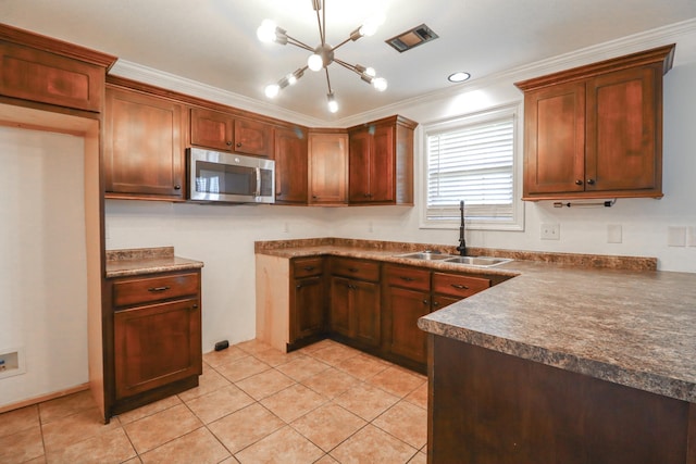 1206 Ryan Ln, Paragould, AR 72450 - kitchen with stainless steel microwave, a chandelier, light tile patterned floors, dark countertops, and crown molding