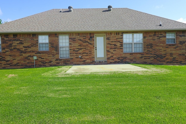 1206 Ryan Ln, Paragould, AR 72450 - back of property featuring roof with shingles, brick siding, and a lawn