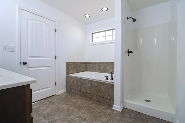 1206 Ryan Ln, Paragould, AR 72450 - bathroom featuring vanity, a bath, a shower, tile patterned flooring, and recessed lighting