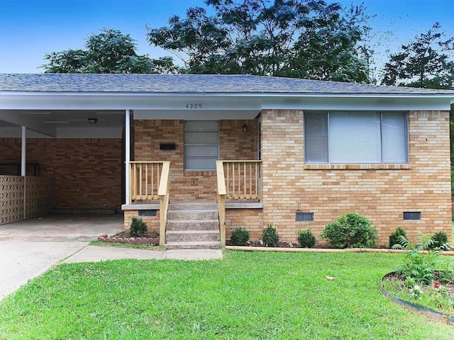 4207-4209 Moss St, North Little Rock, AR 72118 - view of front of house with a front yard, a shingled roof, brick siding, and an attached carport