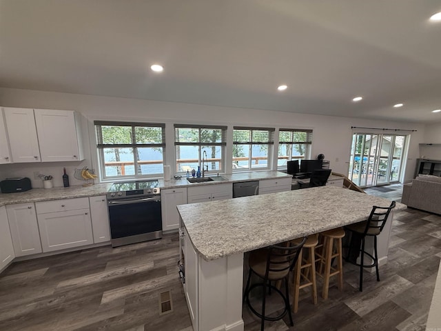 716 S Shore Dr, Horseshoe Bend, AR 72512 - kitchen with stainless steel appliances, dark wood finished floors, open floor plan, white cabinets, and recessed lighting