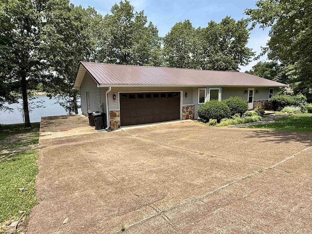 716 S Shore Dr, Horseshoe Bend, AR 72512 - view of front of home featuring an attached garage, stone siding, driveway, and a metal roof