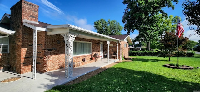 1000 Waverly Rd, Mountain Home, AR 72653 - view of exterior entry with a yard, a chimney, brick siding, and covered porch