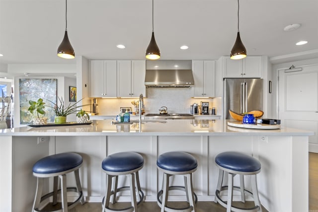 3700 Cantrell Rd Unit 1002, Little Rock, AR 72202 - kitchen with wall chimney range hood, freestanding refrigerator, light countertops, tasteful backsplash, and white cabinetry