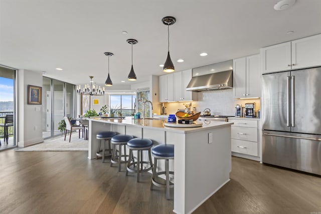 3700 Cantrell Rd Unit 1002, Little Rock, AR 72202 - kitchen with stainless steel refrigerator, wall chimney range hood, dark wood finished floors, white cabinetry, and recessed lighting
