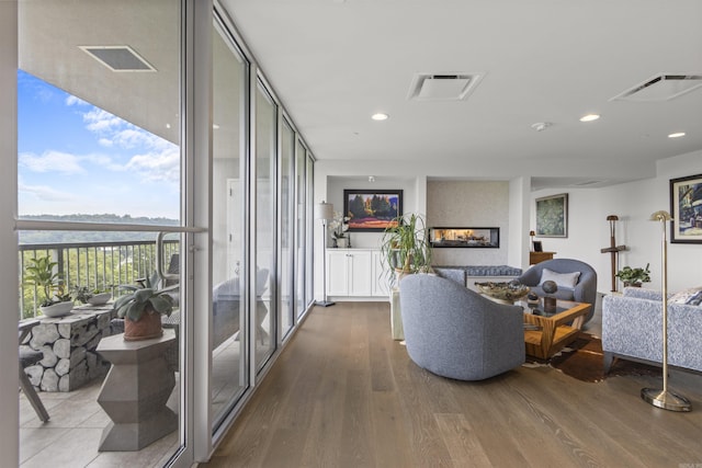 3700 Cantrell Rd Unit 1002, Little Rock, AR 72202 - living room featuring wood finished floors, a glass covered fireplace, a wall of windows, and recessed lighting