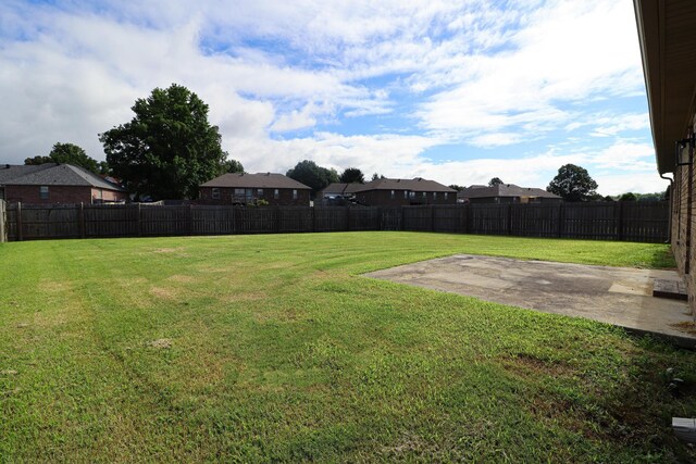 fenced backyard with a patio and a residential view
