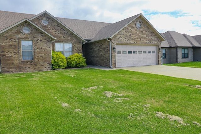 view of front of home featuring an attached garage, driveway, brick siding, a shingled roof, and a front yard