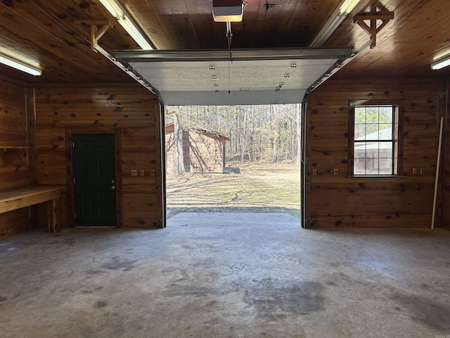 garage featuring wooden walls, wooden ceiling, and a garage door opener