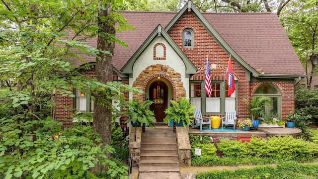 445 Midland St, Little Rock, AR 72205 - tudor-style house featuring brick siding, roof with shingles, and a porch
