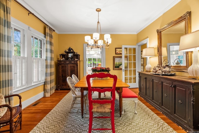 445 Midland St, Little Rock, AR 72205 - dining space with ornamental molding, a chandelier, and wood finished floors