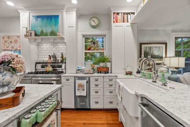 445 Midland St, Little Rock, AR 72205 - kitchen with appliances with stainless steel finishes, light wood-style floors, white cabinetry, light stone countertops, and tasteful backsplash