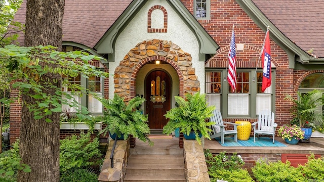 445 Midland St, Little Rock, AR 72205 - view of exterior entry with covered porch, a shingled roof, and brick siding