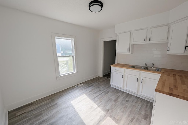 8200 W 34th St, Little Rock, AR 72204 - kitchen featuring butcher block countertops, tasteful backsplash, white cabinetry, and light wood-type flooring