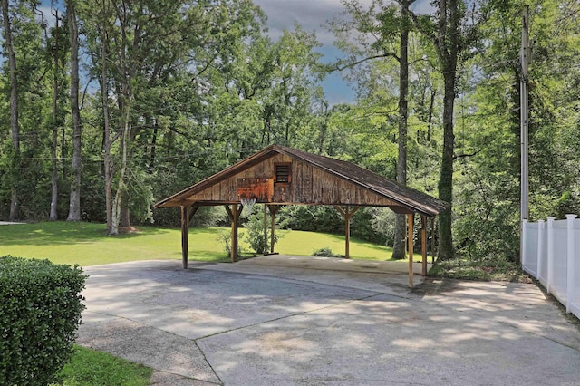 6 Elaine Rd, Sheridan, AR 72150 - view of patio / terrace with concrete driveway, a detached carport, and a view of trees