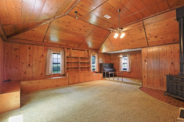 6 Elaine Rd, Sheridan, AR 72150 - unfurnished living room with a wood stove, wood ceiling, a ceiling fan, wooden walls, and vaulted ceiling