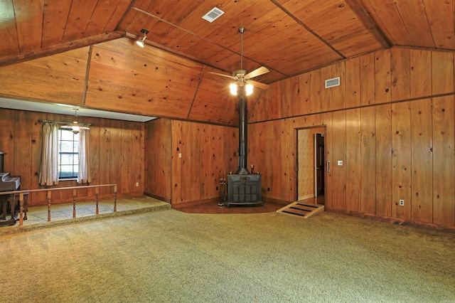 6 Elaine Rd, Sheridan, AR 72150 - empty room with a wood stove, lofted ceiling, wood walls, carpet flooring, and wooden ceiling