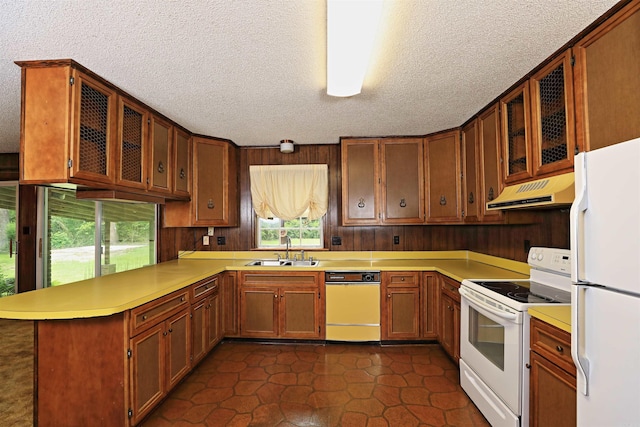 6 Elaine Rd, Sheridan, AR 72150 - kitchen with white appliances, under cabinet range hood, a peninsula, healthy amount of natural light, and a textured ceiling