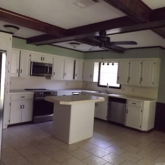 kitchen featuring appliances with stainless steel finishes, beam ceiling, white cabinetry, and a kitchen island