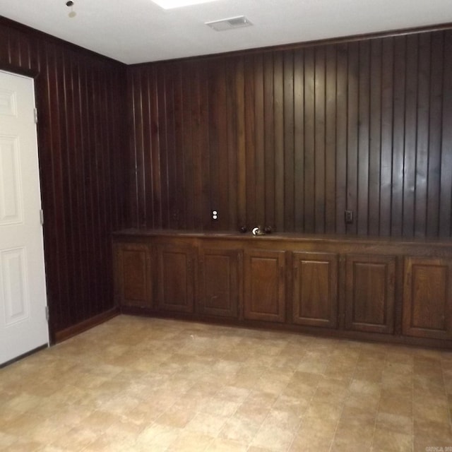 empty room with wood walls and light flooring