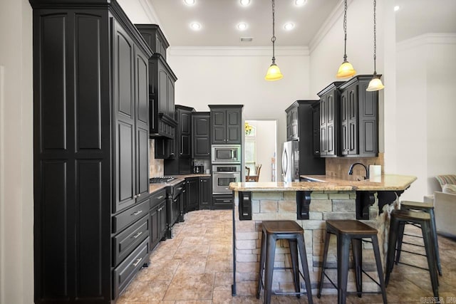 909 Nature Way, Benton, AR 72019 - kitchen featuring stainless steel appliances, a peninsula, dark cabinetry, tasteful backsplash, and crown molding