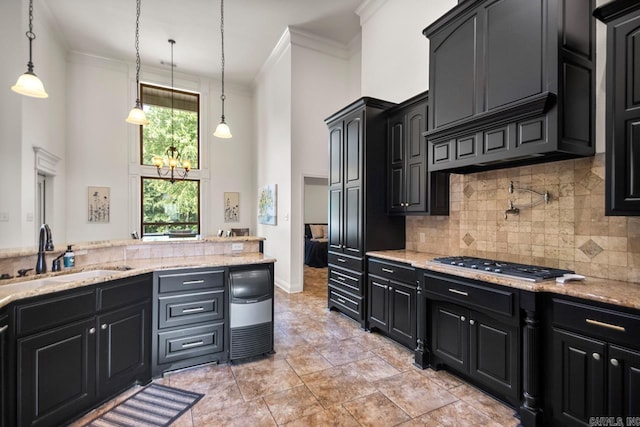 909 Nature Way, Benton, AR 72019 - kitchen featuring dark cabinets, a towering ceiling, stainless steel gas cooktop, crown molding, and backsplash