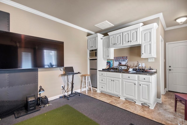 909 Nature Way, Benton, AR 72019 - kitchen with crown molding, white cabinetry, stainless steel microwave, and fridge