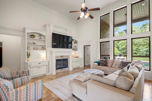 909 Nature Way, Benton, AR 72019 - living room with a high ceiling, ceiling fan, a fireplace, ornamental molding, and built in features