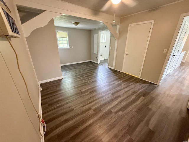 131 N Pine St, Salem, AR 72576 - empty room featuring ceiling fan, dark wood-type flooring, arched walkways, and a wall mounted air conditioner