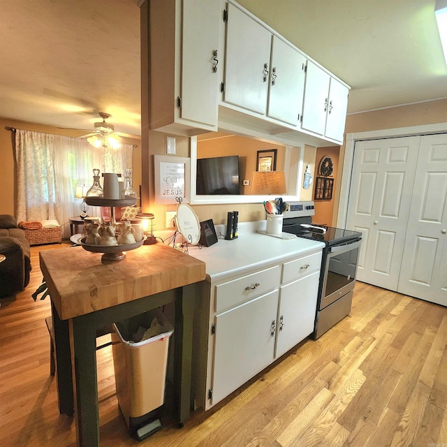 1407 W Front St, Heber Springs, AR 72543 - kitchen featuring stainless steel electric stove, a ceiling fan, light wood-style flooring, white cabinets, and light countertops