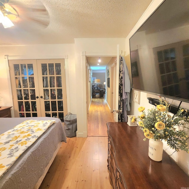 1407 W Front St, Heber Springs, AR 72543 - bedroom featuring light wood-style flooring, french doors, a ceiling fan, and a textured ceiling