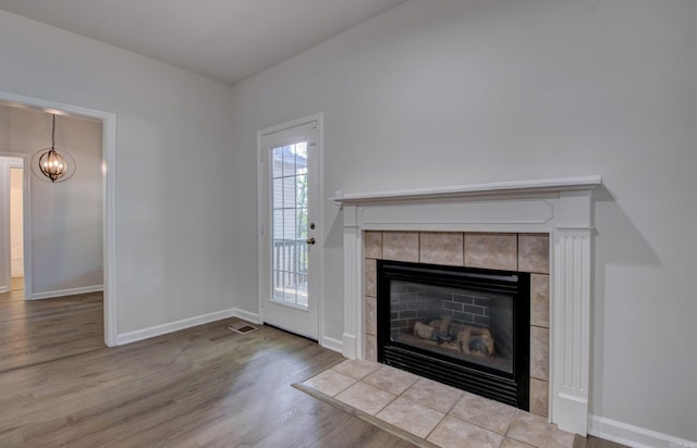 12825 Westglen Dr, Little Rock, AR 72211 - unfurnished living room with a fireplace, wood finished floors, and a chandelier