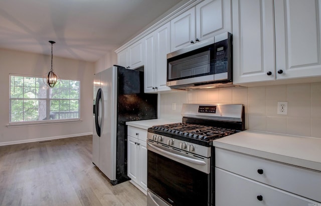 12825 Westglen Dr, Little Rock, AR 72211 - kitchen with appliances with stainless steel finishes, decorative backsplash, white cabinets, light countertops, and light wood finished floors