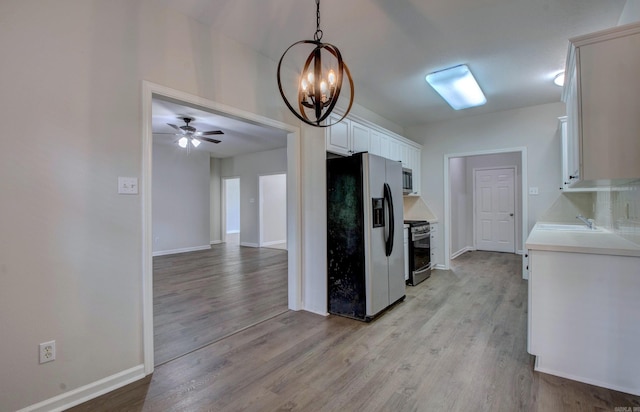 12825 Westglen Dr, Little Rock, AR 72211 - kitchen with stainless steel appliances, light wood-style flooring, light countertops, and a chandelier