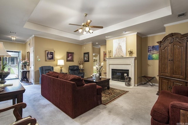 1315 Gleneagles Ct, Little Rock, AR 72211 - living area featuring a tray ceiling, light carpet, ceiling fan, a glass covered fireplace, and crown molding