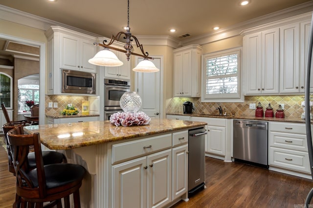 103 Falata Cir, Little Rock, AR 72223 - kitchen with stainless steel appliances, a kitchen island, decorative backsplash, white cabinets, and dark wood-style floors