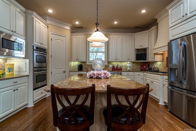 103 Falata Cir, Little Rock, AR 72223 - kitchen featuring stainless steel appliances, dark wood finished floors, ornamental molding, a breakfast bar, and decorative light fixtures