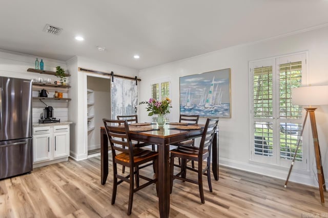 4 Coachlight Cir, Little Rock, AR 72227 - dining area featuring a barn door, crown molding, light wood-style floors, and recessed lighting