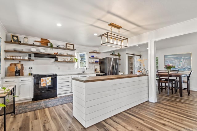 4 Coachlight Cir, Little Rock, AR 72227 - kitchen with freestanding refrigerator, black range, open shelves, range hood, and butcher block countertops