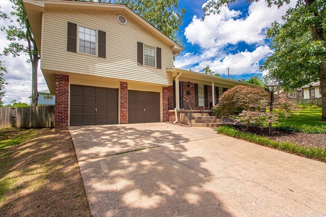 4 Coachlight Cir, Little Rock, AR 72227 - split level home with brick siding, an attached garage, concrete driveway, and covered porch
