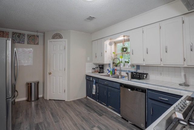 103 N Greer Dr, Searcy, AR 72143 - kitchen featuring appliances with stainless steel finishes, blue cabinetry, white cabinetry, dark wood-style flooring, and a textured ceiling