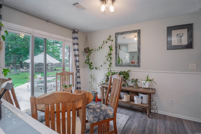 103 N Greer Dr, Searcy, AR 72143 - dining room featuring wood finished floors, a textured ceiling, and a wainscoted wall