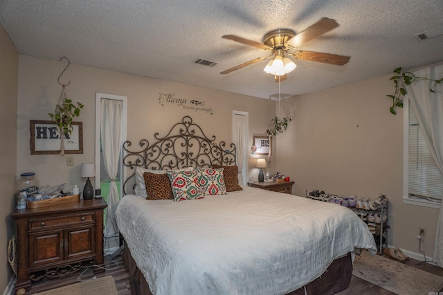 103 N Greer Dr, Searcy, AR 72143 - bedroom featuring a textured ceiling, dark wood-style floors, and a ceiling fan