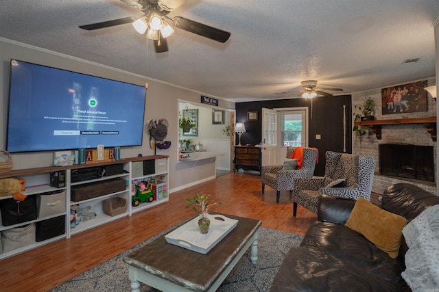 103 N Greer Dr, Searcy, AR 72143 - living room with a ceiling fan, a textured ceiling, a brick fireplace, wood finished floors, and ornamental molding