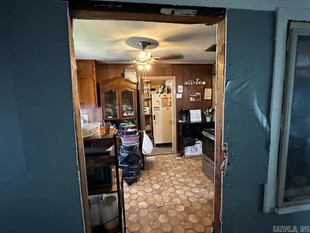 1901 S Buerkle St, Stuttgart, AR 72160 - kitchen featuring freestanding refrigerator, ceiling fan, wooden walls, and stainless steel range