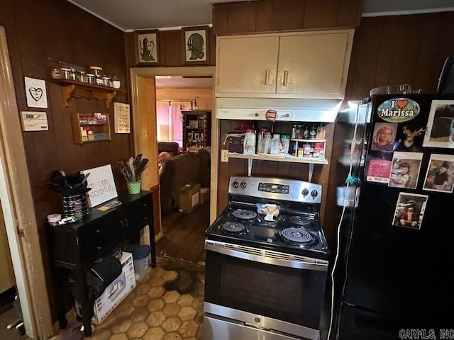 1901 S Buerkle St, Stuttgart, AR 72160 - kitchen with freestanding refrigerator, stainless steel range with electric cooktop, range hood, and wooden walls