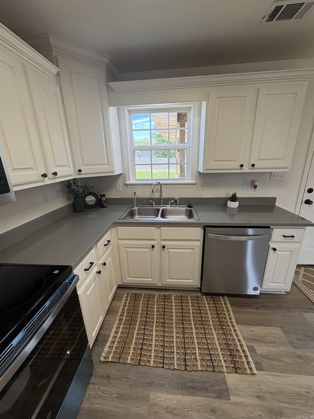 1901 N 19th St, Paragould, AR 72450 - kitchen featuring appliances with stainless steel finishes, dark wood-type flooring, white cabinets, and dark countertops