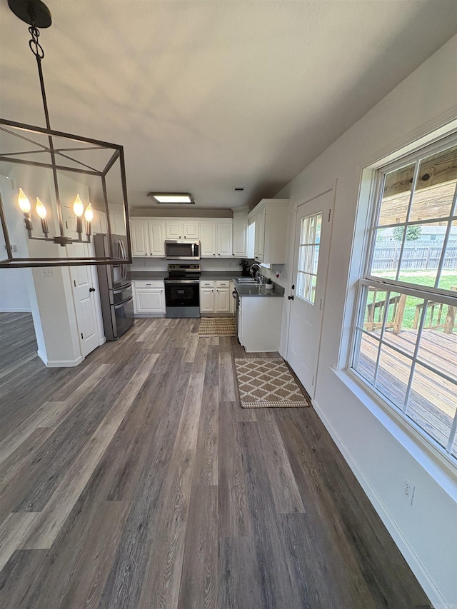 1901 N 19th St, Paragould, AR 72450 - kitchen featuring stainless steel appliances, dark wood-type flooring, dark countertops, and white cabinets