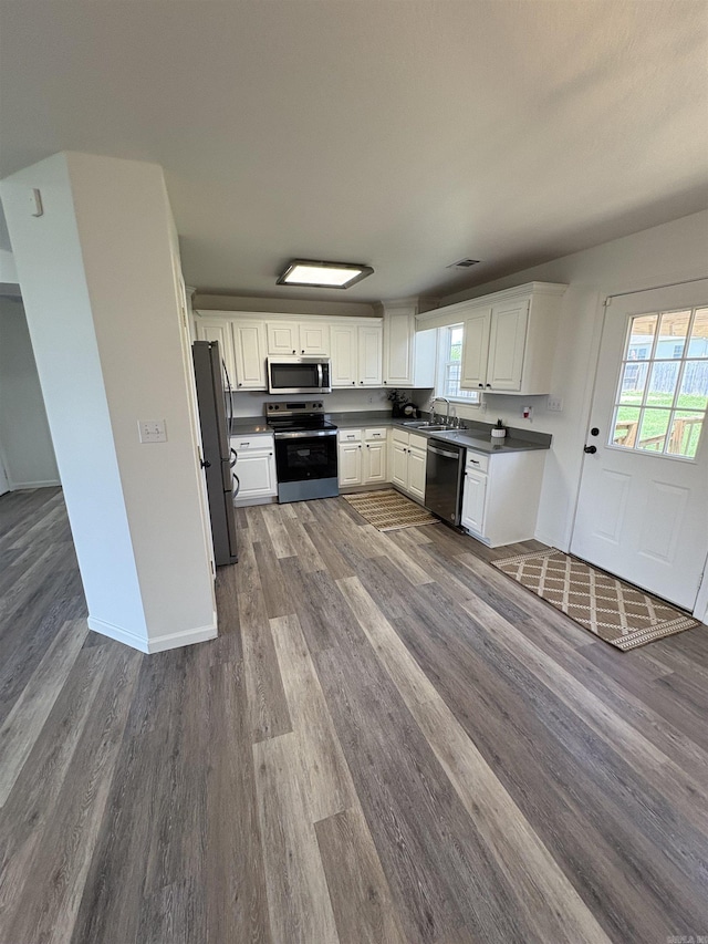 1901 N 19th St, Paragould, AR 72450 - kitchen with appliances with stainless steel finishes, wood finished floors, and white cabinetry